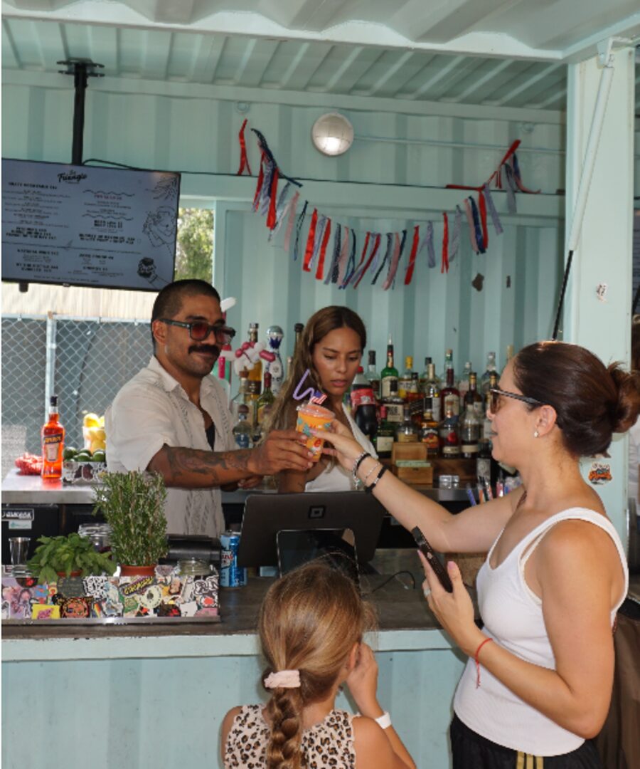 Bartenders serving a family with a young child at the bar counter at The Triangle at Little River